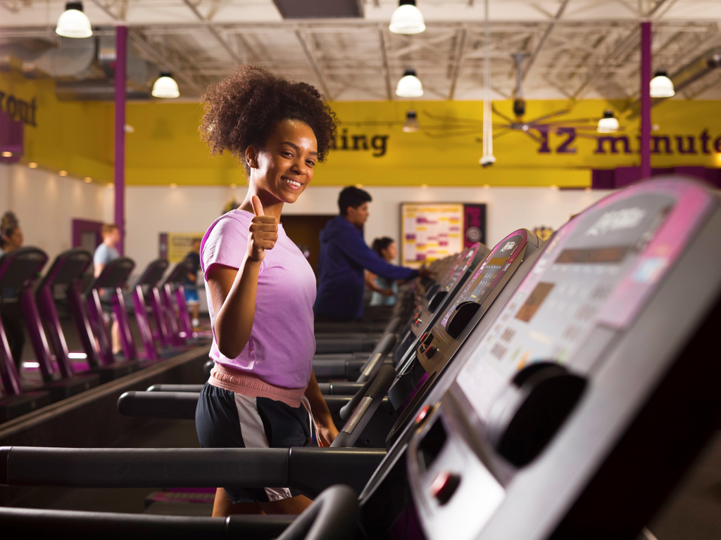 A girl giving thumbs up while working out at Planet Fitness