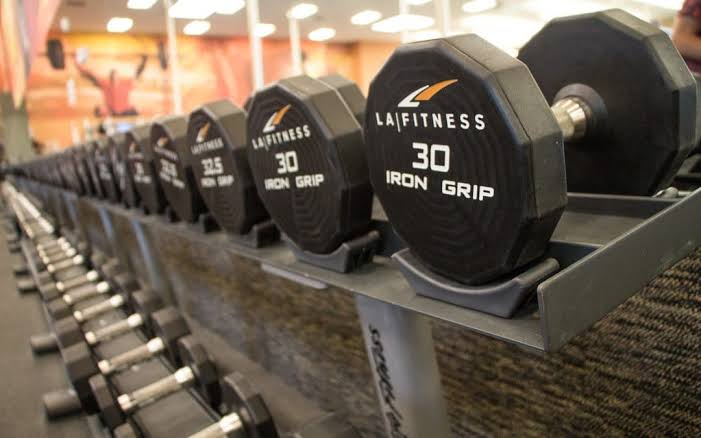 Close-up of LA Fitness dumbbells neatly arranged in a gym for fitness enthusiasts.
